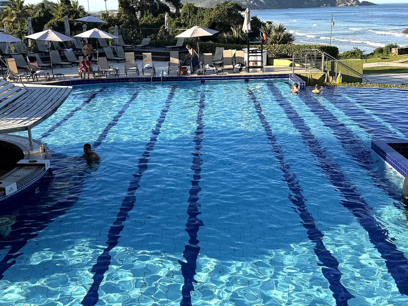 Piscina do Costão do Santinho com raias, guarda-sóis e o mar ao fundo