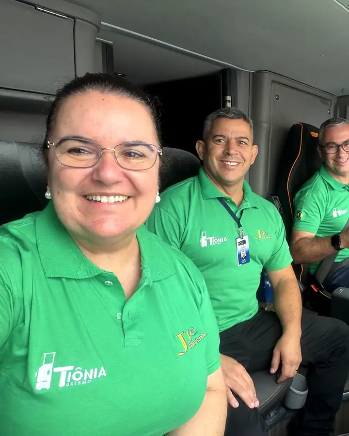 A equipe da Tiônia, com a camisa da agência, dentro do ônibus de turismo antes da saída